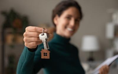 woman holding keychain with house on it