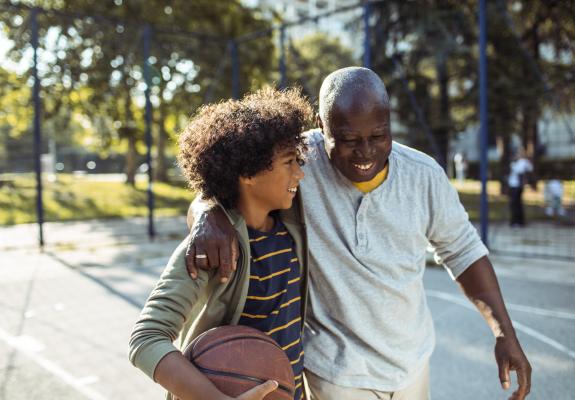 young boy playing basketball with his grandfather