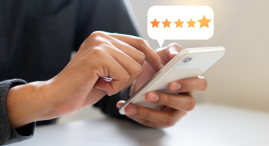 person holding a phone with a five star review overlaid