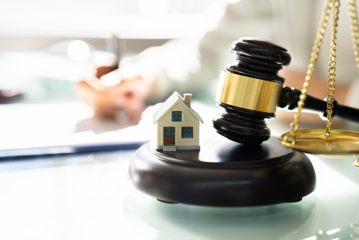 Photo of a gavel, the scales of justice and a house.