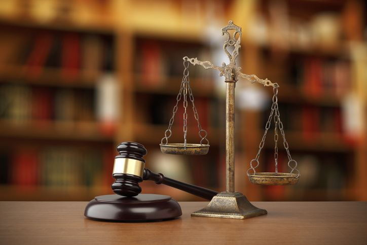 Photo of a court gavel next to scales of justice.