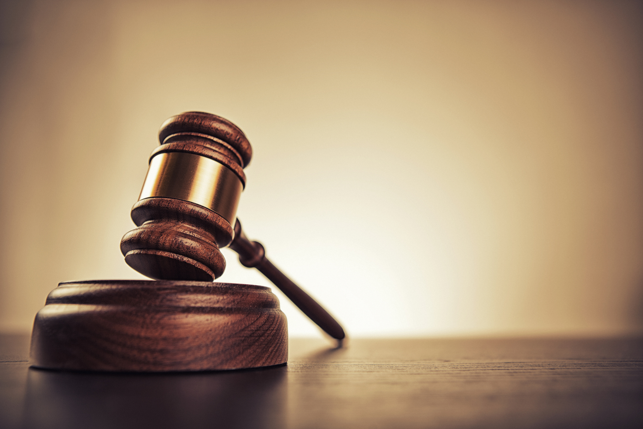 A gavel rests on a sound block in a courtroom