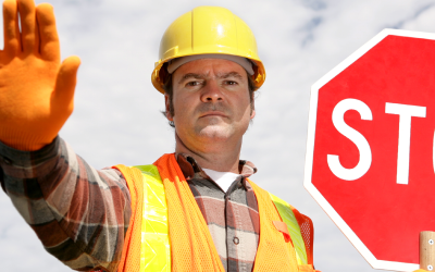 man with a hard hat and stop sign
