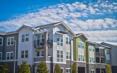 Photo of an apartment community amid sunny skies.