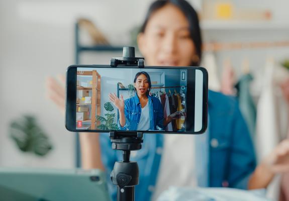 young woman filming herself on her phone