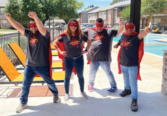 four people dressed in superhero costumes