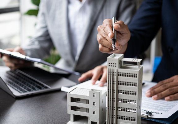 person pointing to model of large-scale construction project