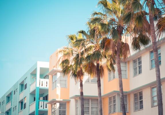 beachside apartments with palm trees in front