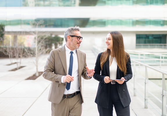 a middle aged man and young woman in business attire