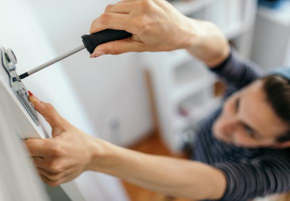 Women fixing storage unit door