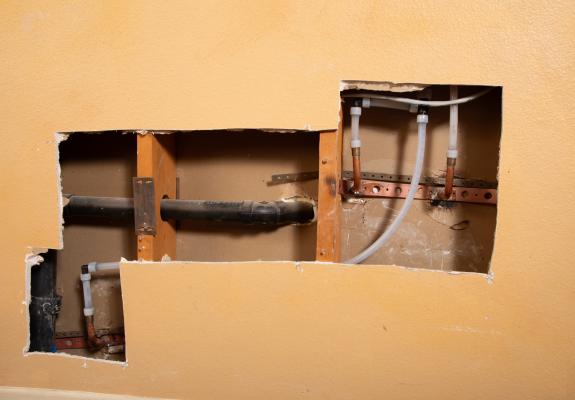 Cut out of a plumbing line in a wall.