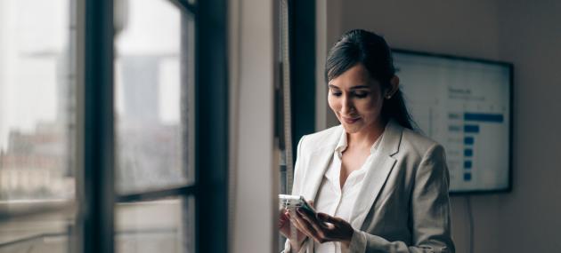 woman in business attire looking at phone