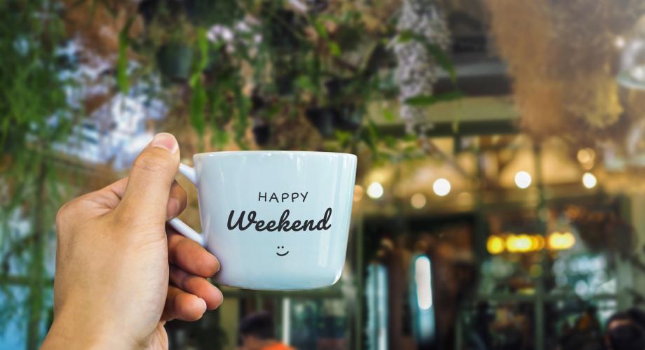 person holding mug that says "happy weekend"