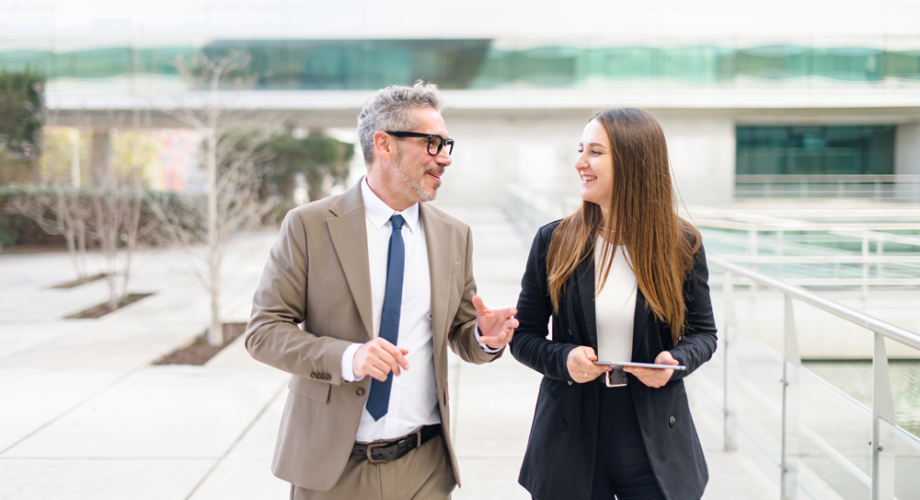 a middle aged man and young woman in business attire