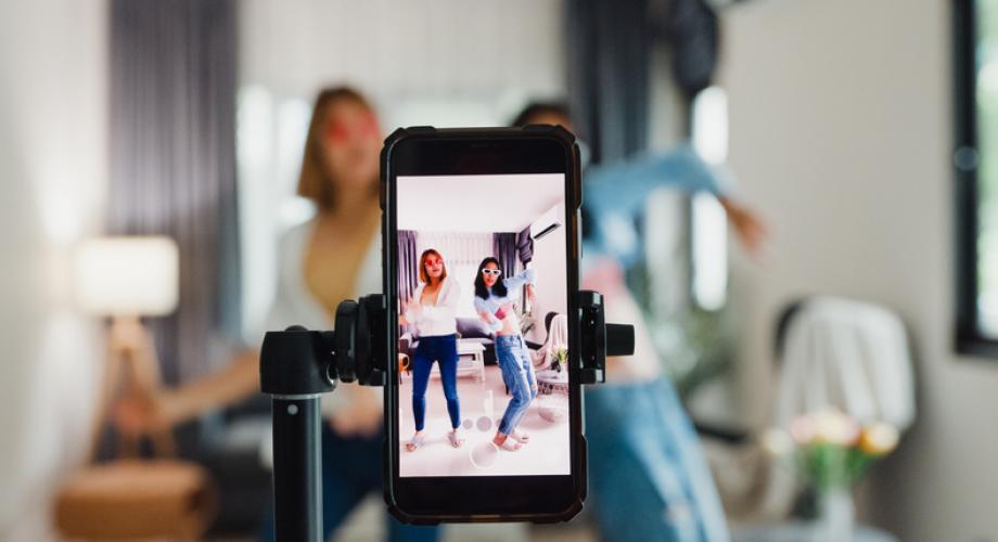 two young women filming a video on their phone