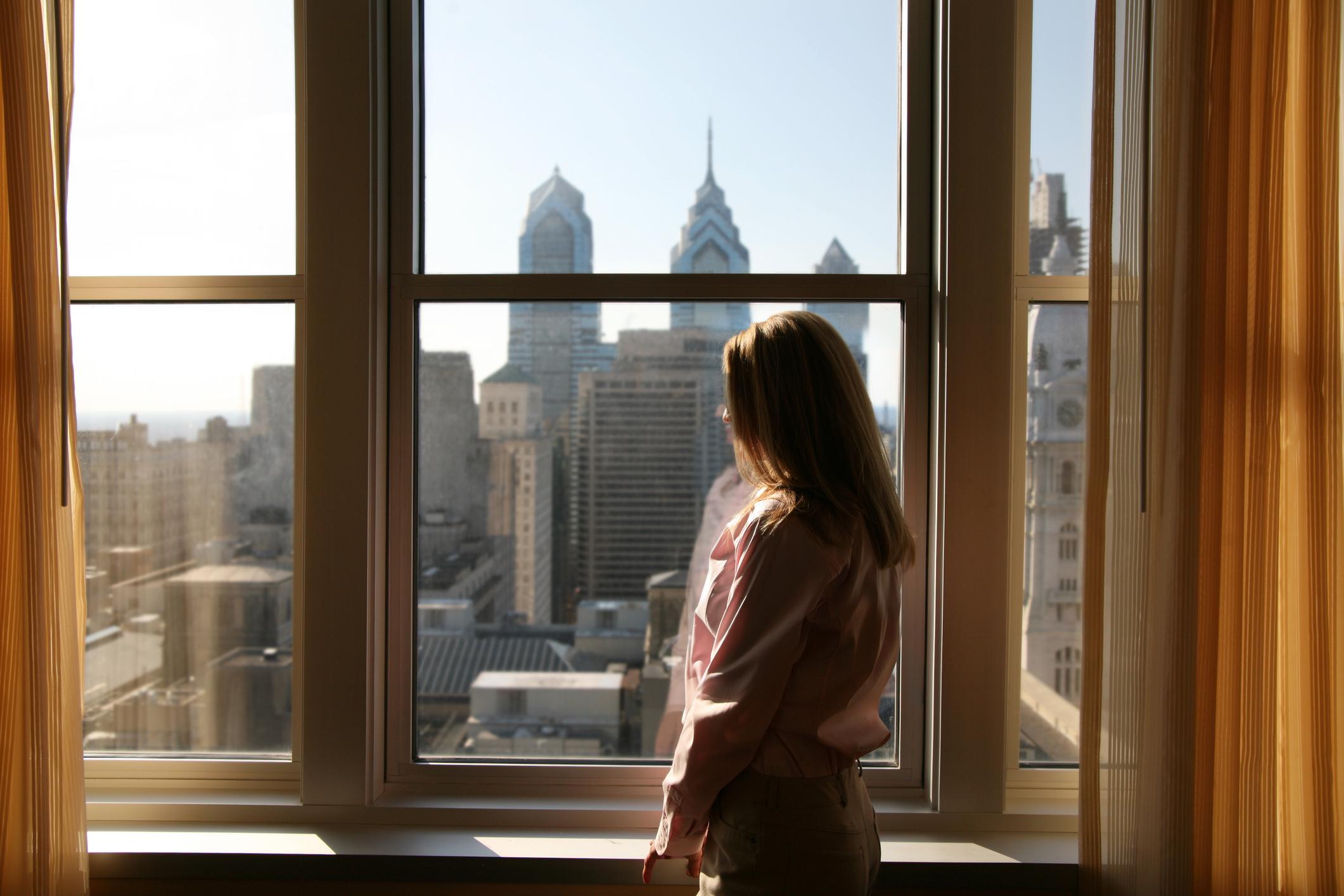 woman at a window overlooking the philadelphia skyline
