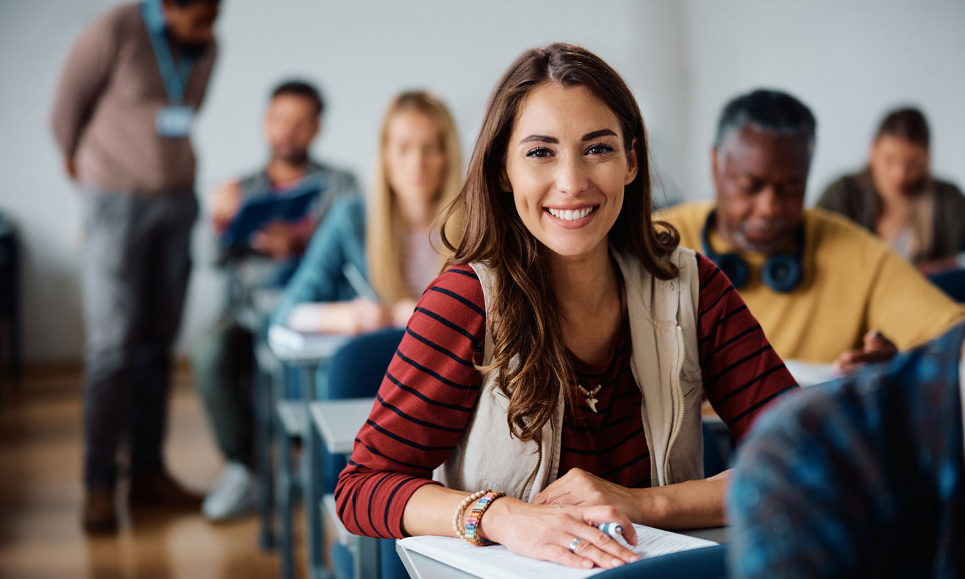 young woman in classroom with other adults learning