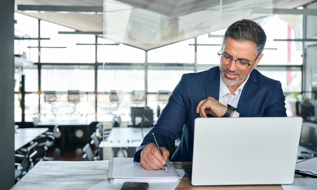man taking notes at computer