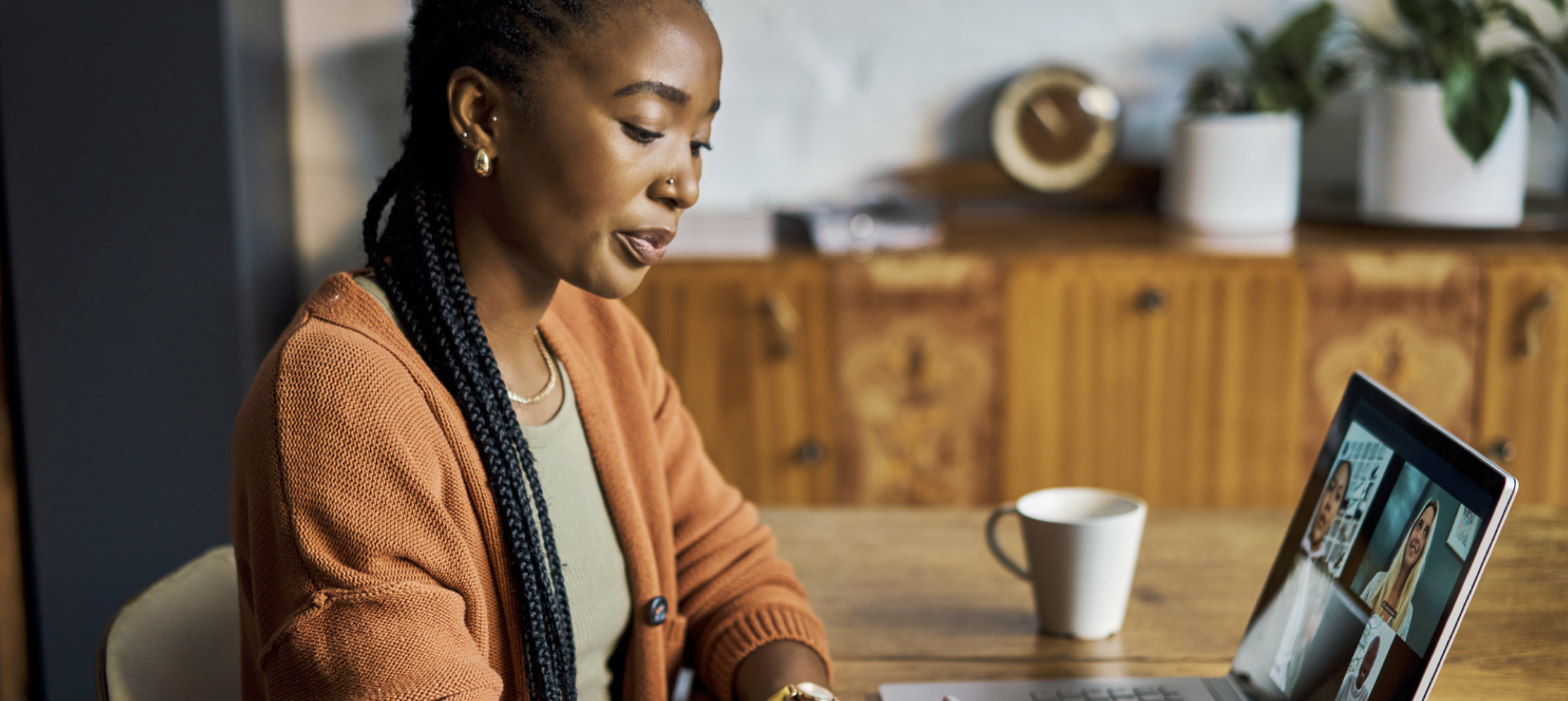 woman watching a webinar at kitchen table